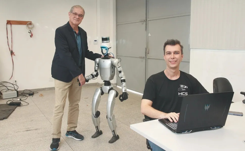 Professors Ricardo Carminati de Mello and Alberto Ferreira with the Prometheus humanoid robot